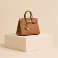 Brown handbag on a beige platform with a beige background