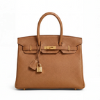 Brown leather handbag with gold hardware on a white background