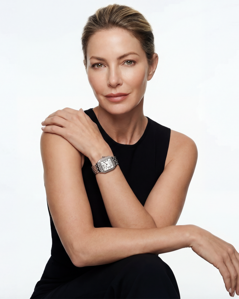 Woman wearing a black dress and a diamond watch on a white background